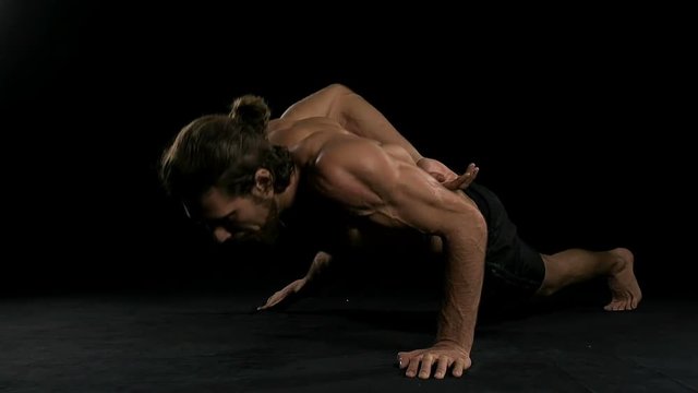 Man doing push up with black background. Half naked man, slow motion.