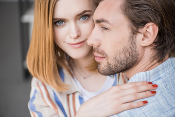 portrait of smiling young woman embracing boyfriend