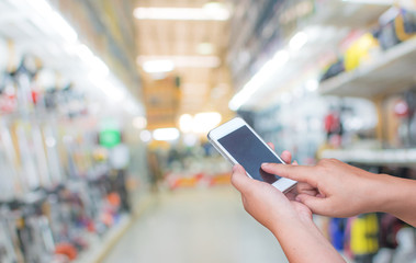 blurred photo smartphone on supermarket store on background with bokeh.