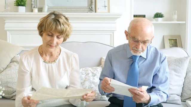 Senior happy couple together reading old letters, remember the past