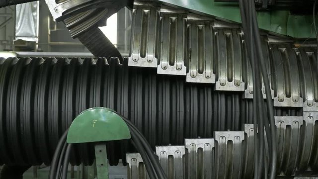 Manufacture of plastic water pipes. Manufacturing of tubes to the factory. The process of making plastic pipes on the machine tool with the use of water and air pressure. Special corrugated forms of