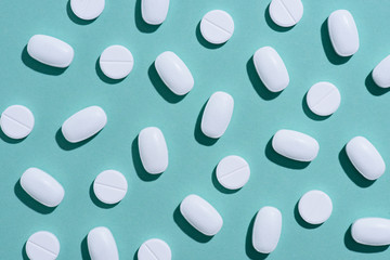 top view of white pills on blue surface