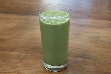 Green smoothie on wood table.