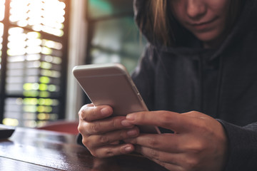 Closeup image of a woman holding , using and looking at smart phone