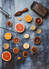 top view of wooden squeezer, grater, bottle and drinking straws on table