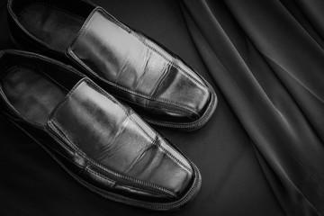 A pair of Black leather elegant  men shoes on black background. Gentleman Shoes Fashion Background.