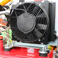 A large black industrial fan mounted on a red frame.