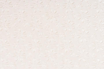 Beige self made paper pressed flowers sheet texture background. Embossed lace pattern. 
