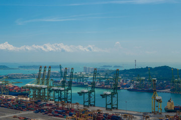 Beautiful aerial view of Singapore industrial, commercial port. Cargo ship loading by cranes. Containers in the harbour.