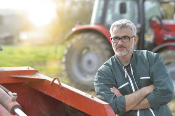 Farmer standing by tractor outside the barn