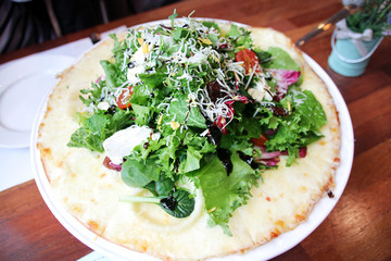 A Gorgonzola Pizza with Vegetables Salad at a Restaurant.