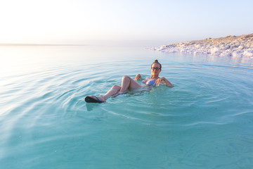 Woman swimming in salty water of a Dead Sea