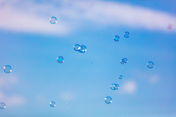 Soap bubbles in flight against the sky