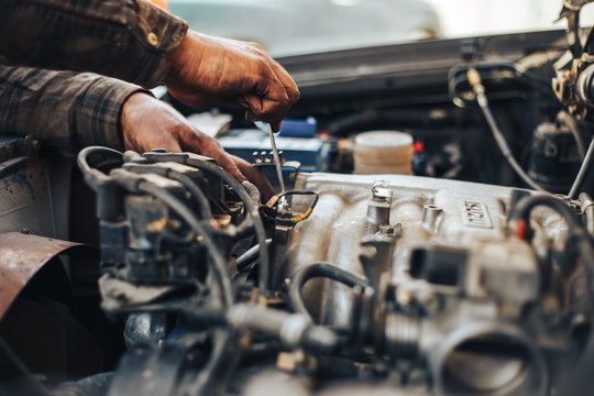 dirty hands of auto mechanic reparing car