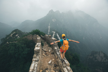 Obraz premium successful woman hiker open arms on the top of mountain