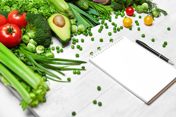 Shopping List. Green Vegetables And Notebook On Table