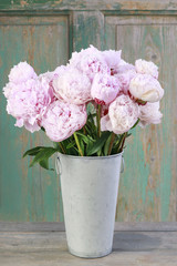 Bouquet of pink peonies in vintage bucket.