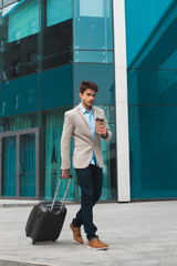 Success is often achieved! Full length vertical shot of young handsome male business traveler...