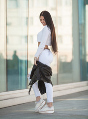 Obraz premium Fashion lifestyle portrait of young happy pretty woman laughing and having fun on the street at nice sunny summer day. portrait of young pretty stylish girl with long hair.