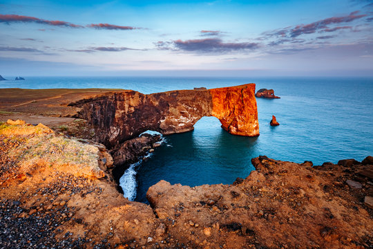 Amazing black arch of lava standing in the sea. Location cape Dyrholaey, Iceland, Europe.