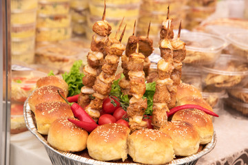 Delicious rolls, red pepper, cherry tomatoes and a barbeque on a stick on a plate