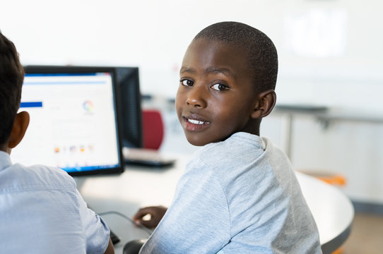 African boy using computer at school