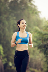 Fototapeta premium young sports woman runner running on road