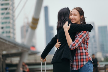 Joyful mother and daughter hug together after mother back form travel
