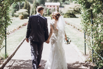 Romantic wedding moment, couple of newlyweds smiling portrait, bride and groom hug while on a walk...