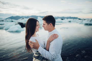 Happy stylish smiling couple walking and kissing in Iceland , on
