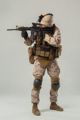 Soldier in camouflage holding rifle