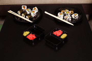 Delicious and healthy vegan rolls lie in a black plate on the table.