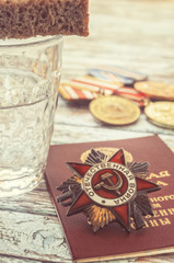 The funeral glass of vodka covered with a piece of rye bread and an award of the veteran of the Great Patriotic War of 1941-1945.