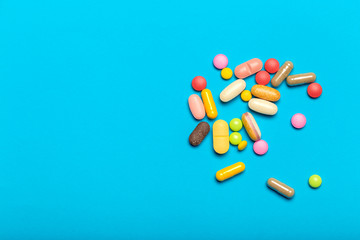 Pills are scattered over a blue background