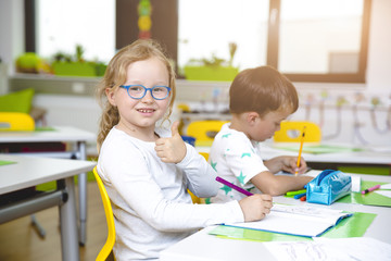 At School - Beautiful young kids have fun in school while learning in classroom