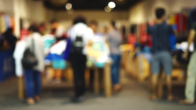 Blurred image of people buying clothes at shopping mall
