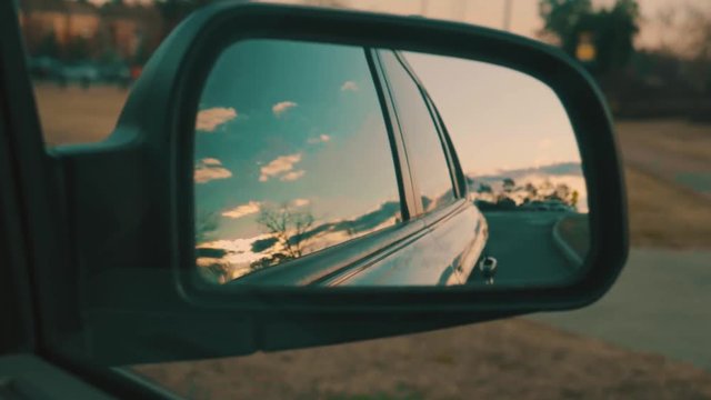 Beautiful Sunset view from car's side mirror while driving down the road