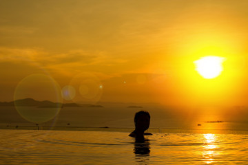 Sunset for freedom concept with woman in the water and beautiful silhouette.  Totally free and living a healthy life.