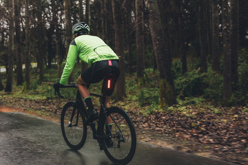 Fototapeta premium Male cyclist training on wet road