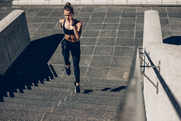 Sportswoman exercising on staircase