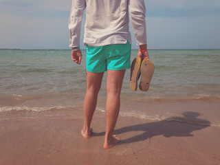 Man enjoying on the tropical sand beach. Summer concept.