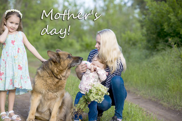 Mother day. Mother with two daughters and a dog, a German Shepherd on a green grass