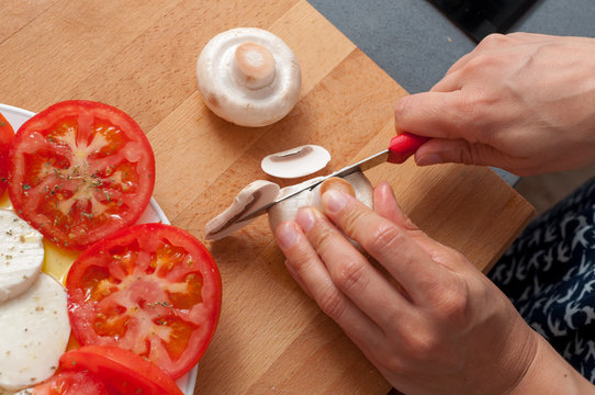 woman preparing salad of tomatoes and buffalo cheese