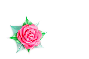 Rose with green leaves from a tape on a white background with place for text. Artificial flower made of fabric.