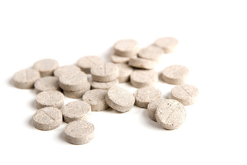 Fototapeta na wymiar Pills based on dried herbs on a white background. Homeopathy.