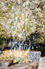 Der kleine Wasserfall: Wasser rinnt den Stein herunter.