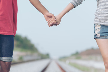 Couple hand holding Lovers walk on the railway,life partner concept