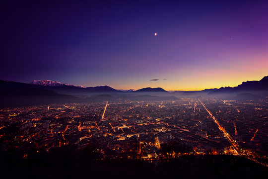 Grenoble after sunset surrouned by mountains