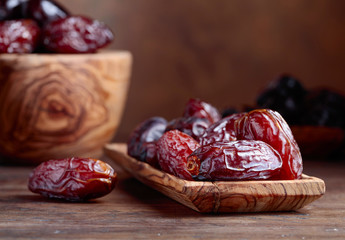 Juicy dates on wooden table .