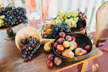 on the wooden table are plates with fresh fruits and berries